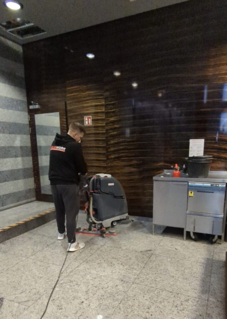 Pracownik Solid Work, myjący maszyną posadzkę w trakcie sprzątanie V Tower dla produkcji filmowej