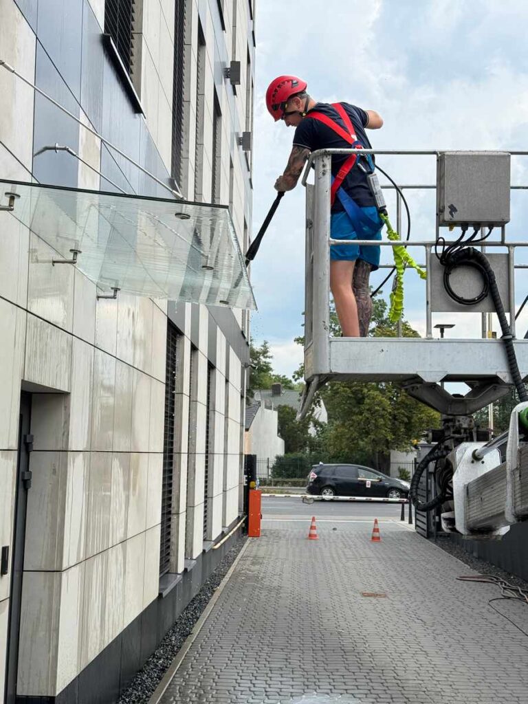 Czyszczenie szklanego daszku nad wejściem do biurowca