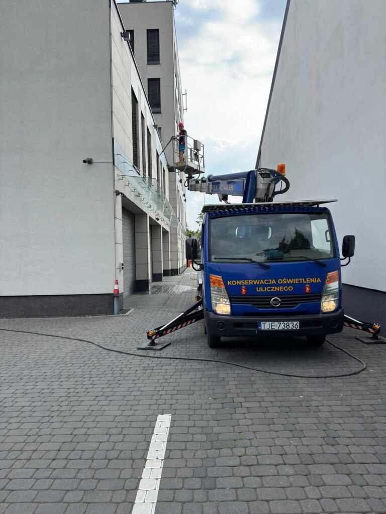 Podnośnik koszowy rozstawiony przed biurowcem wczesnym rankiem